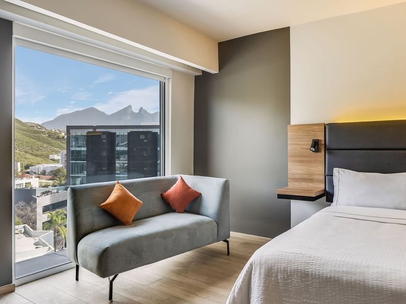 Executive Room with a Couch and a bed with wooden flooring at Fiesta Inn