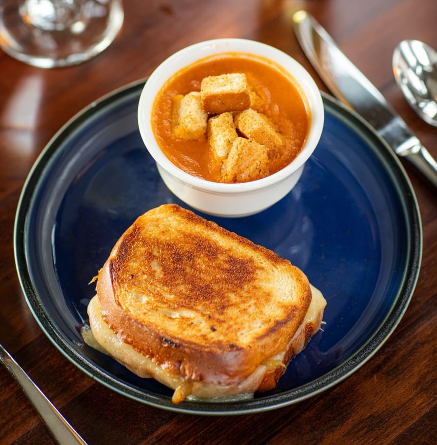 Golden grilled cheese sandwich beside a bowl of tomato soup at Regency Restaurant in Portland Regency Hotel & Spa