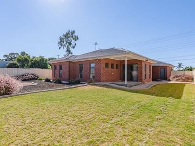 Exterior of La Trobe University Regional Housing in Mildura with lush green lawn and brick facade.