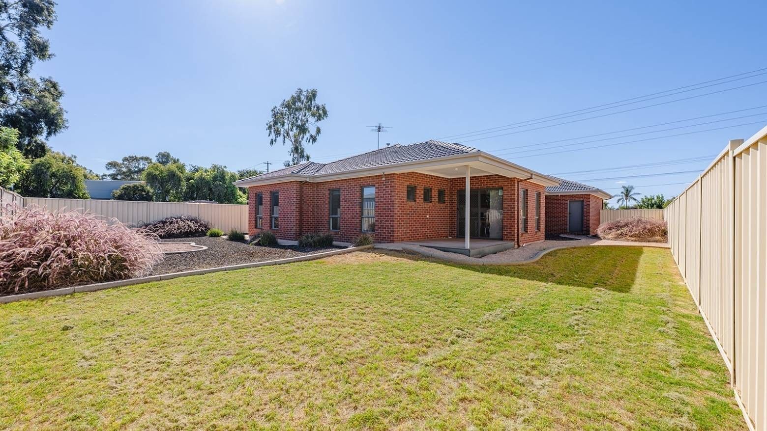 Exterior of La Trobe University Regional Housing in Mildura with lush green lawn and brick facade.