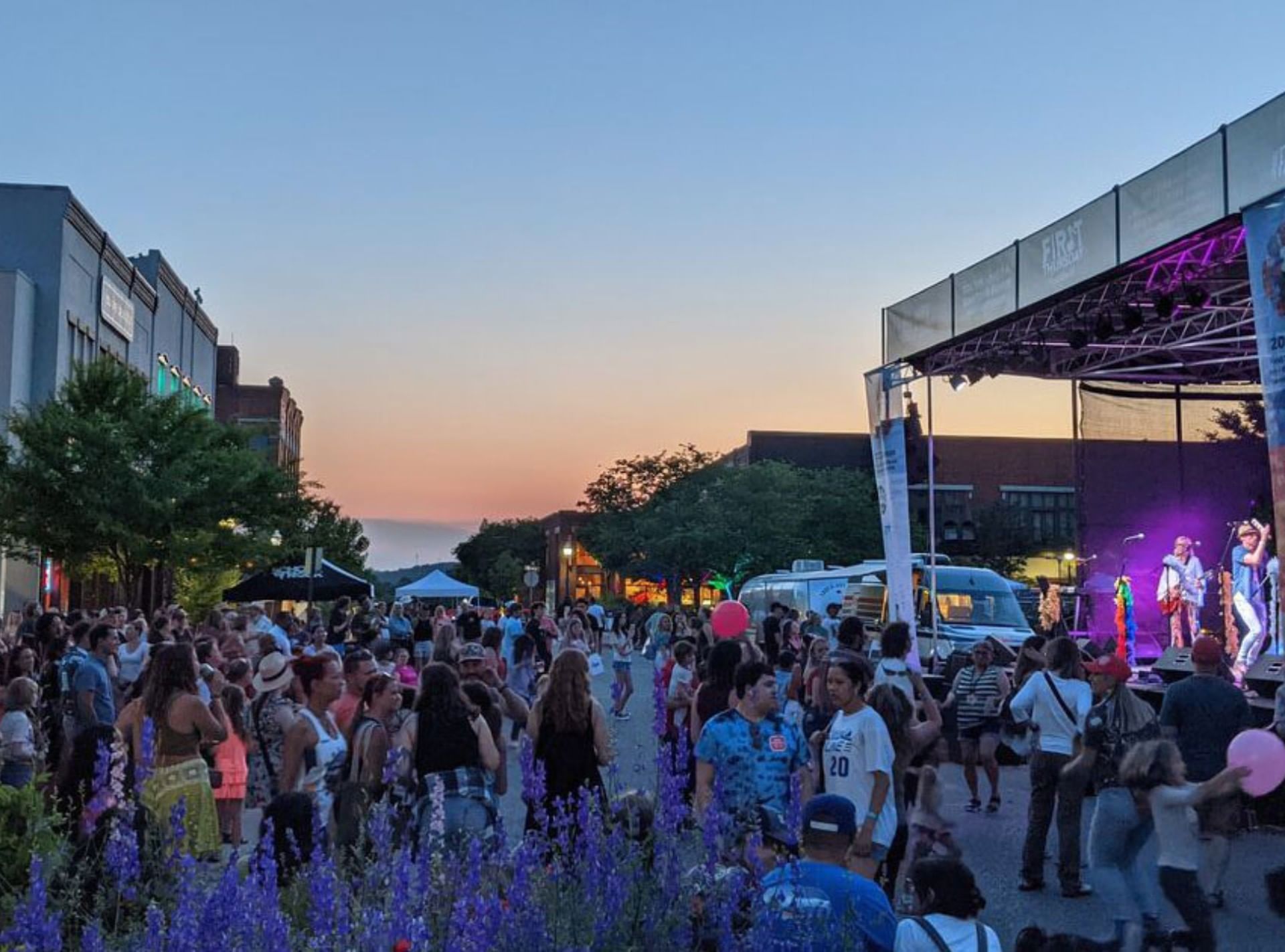 A crowd of people walking the main stree of Fayetteville with live music