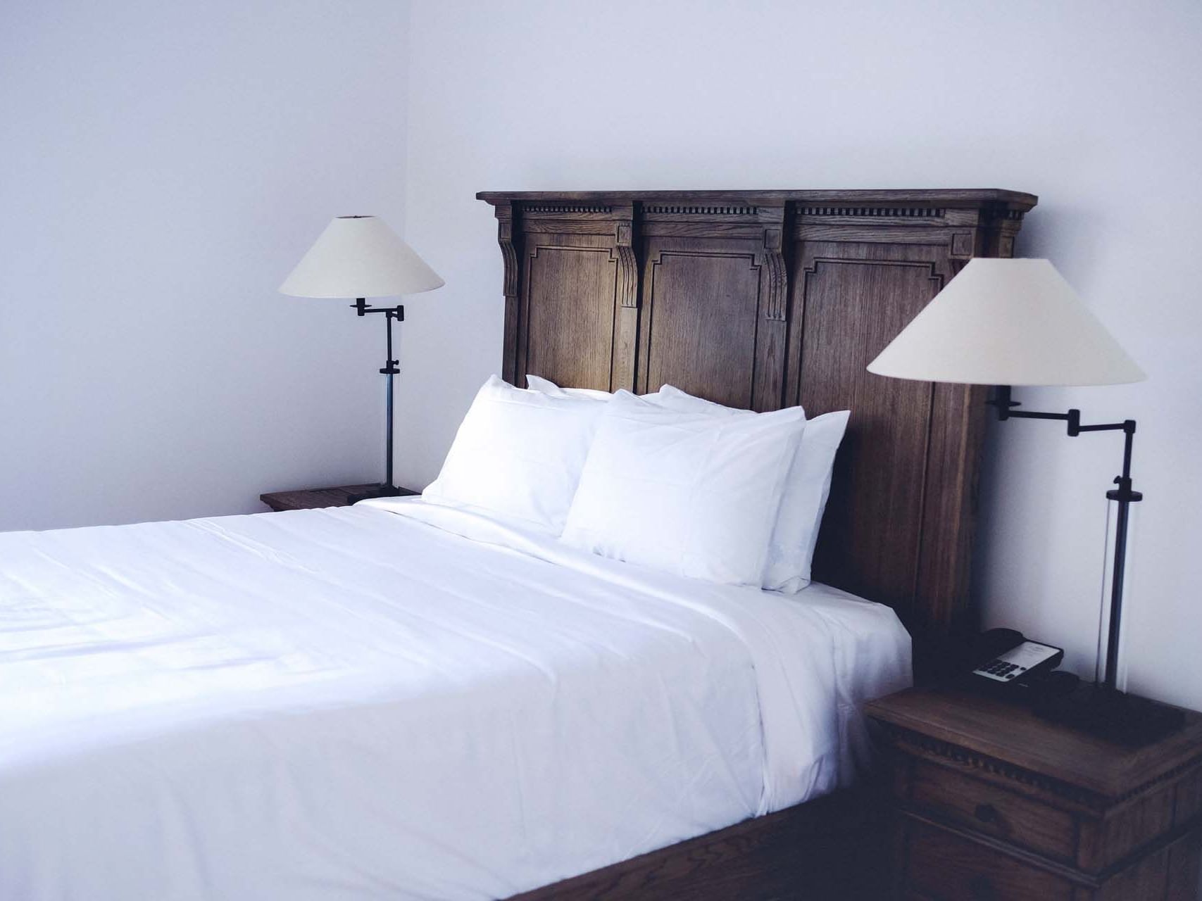 A bed in a room with night lamps at The Royal Frenchmen Hotel