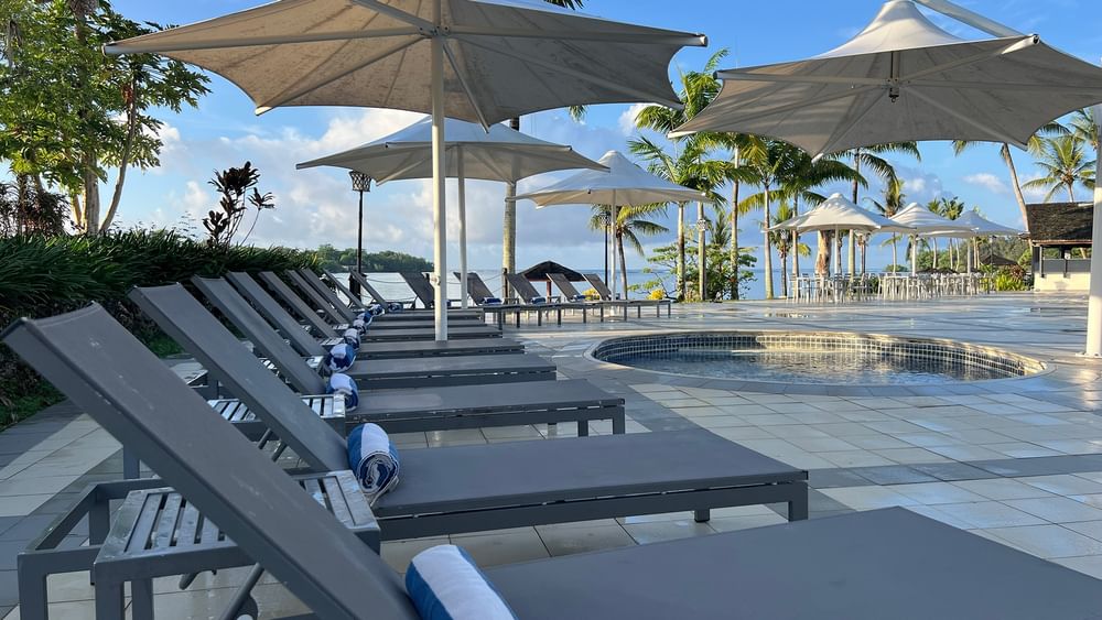 Poolside with loungers and umbrellas at Warwick Le Lagon - Vanuatu in Efate.