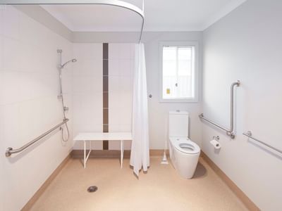 Clean bathroom with accessible toilet, shower, and support bars at La Trobe University Regional Housing – Shepparton.