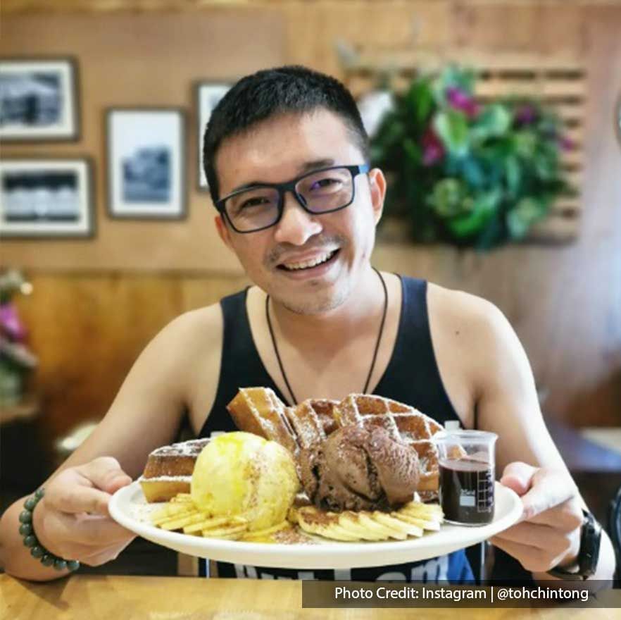 A man was taking pictures with a plate of waffles and ice creams at Caffeine Chemistry Coffee cafe - Lexis Suites Penang