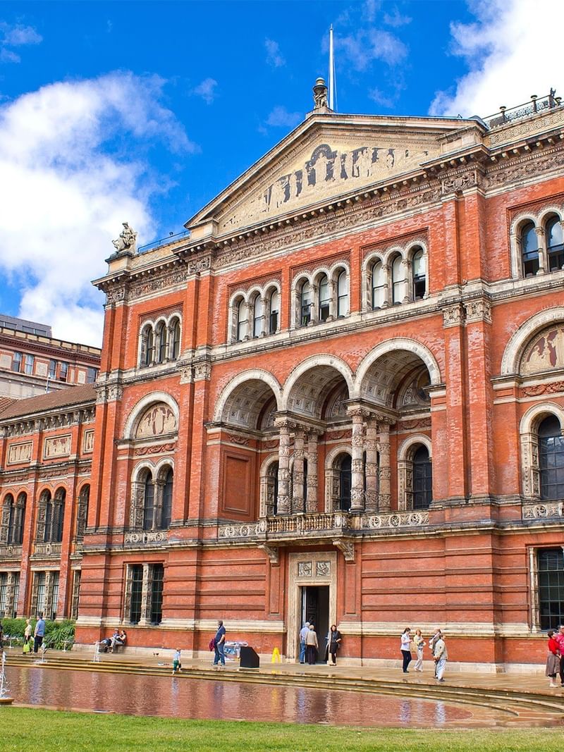 Brick exterior of the V&A Museum with ornate arches near The Capital Hotel, Apartments and Townhouse
