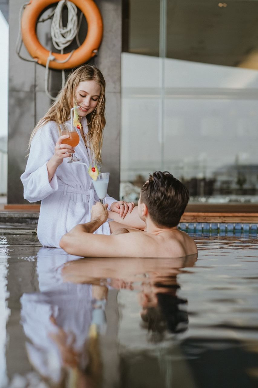 Couple enjoying cocktails in the pool at Po Hotel Semarang