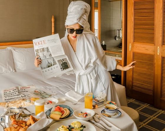 A girl having her breakfast on the bed at Grand Lapa Hotel
