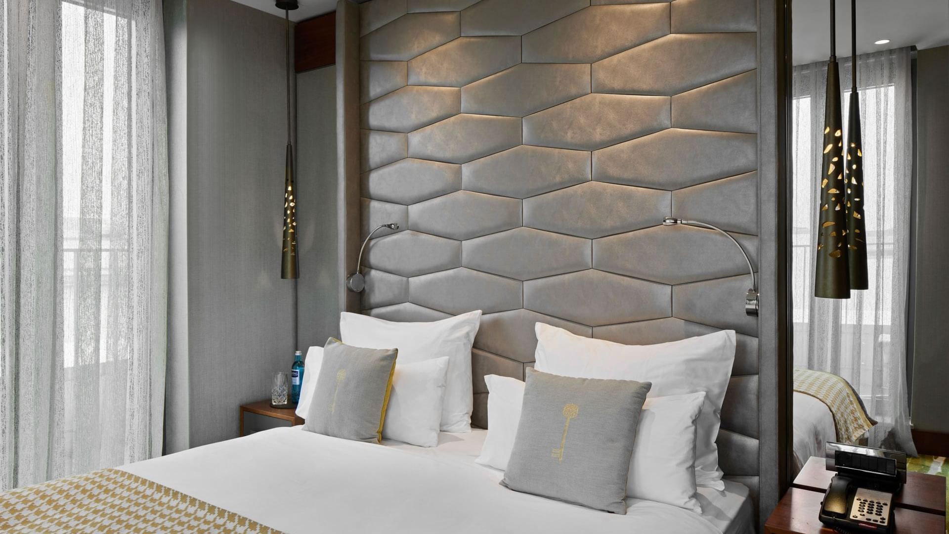 Gemütliches Bett mit Kissen und Beistelltischen in der Junior Suite im Titanic Chaussee Berlin