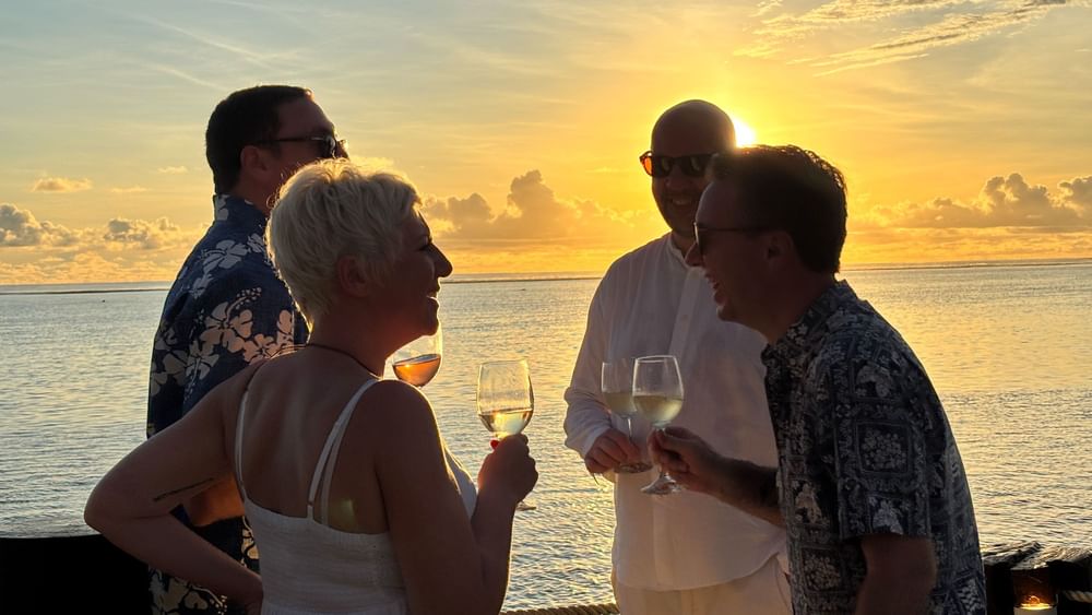 Guests enjoying a sunset wine tasting by the ocean at Warwick Fiji Resort and Spa.