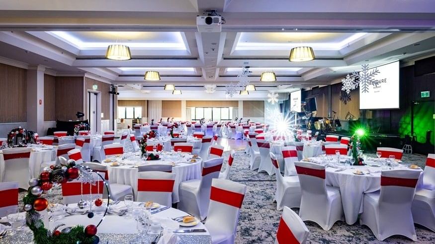 Decorated ballroom with tables and chairs set for an event at Mercure Gold Coast Resort, Carrara.