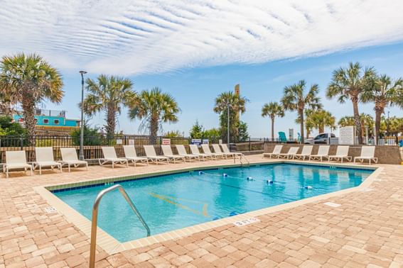 Outdoor swimming pool with arranged sun beds at The Yachtsman Resort