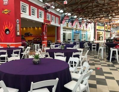 Tables arranged for an event in a venue at the Orlando Auto Museum.
