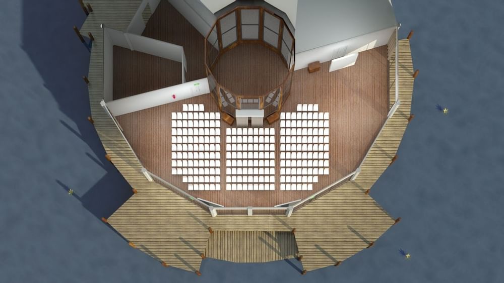 Aerial view of Lily’s on the Lagoon Theatre with chairs and a wooden deck over the water at Novotel Sunshine Coast Resort