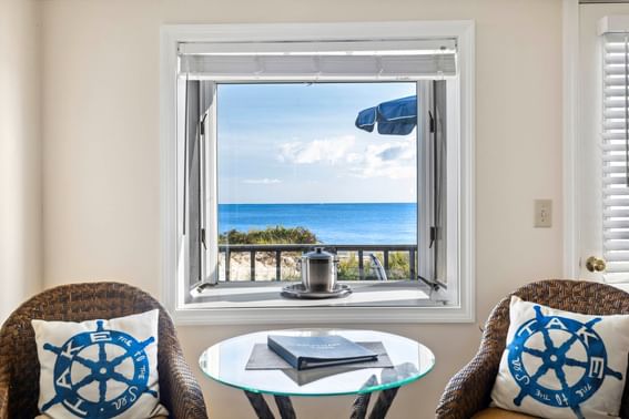 Sea view from the window by arranged seating in Oceantide Beachfront King Efficiency room at Chatham Tides Resort