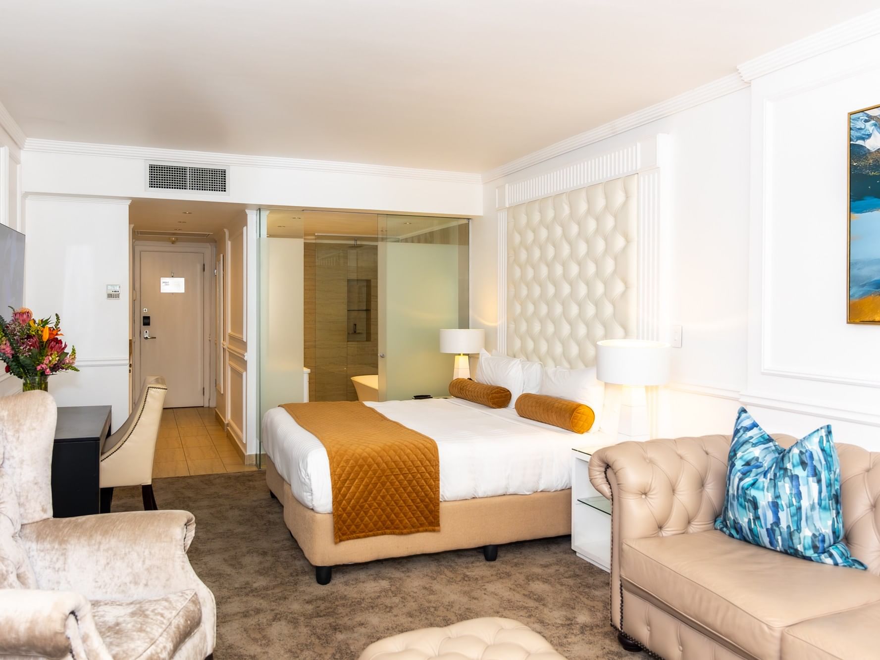Superior Deluxe room with white bedding, tufted headboard, beige sofa, and modern decor at Pepperclub Hotel Cape Town