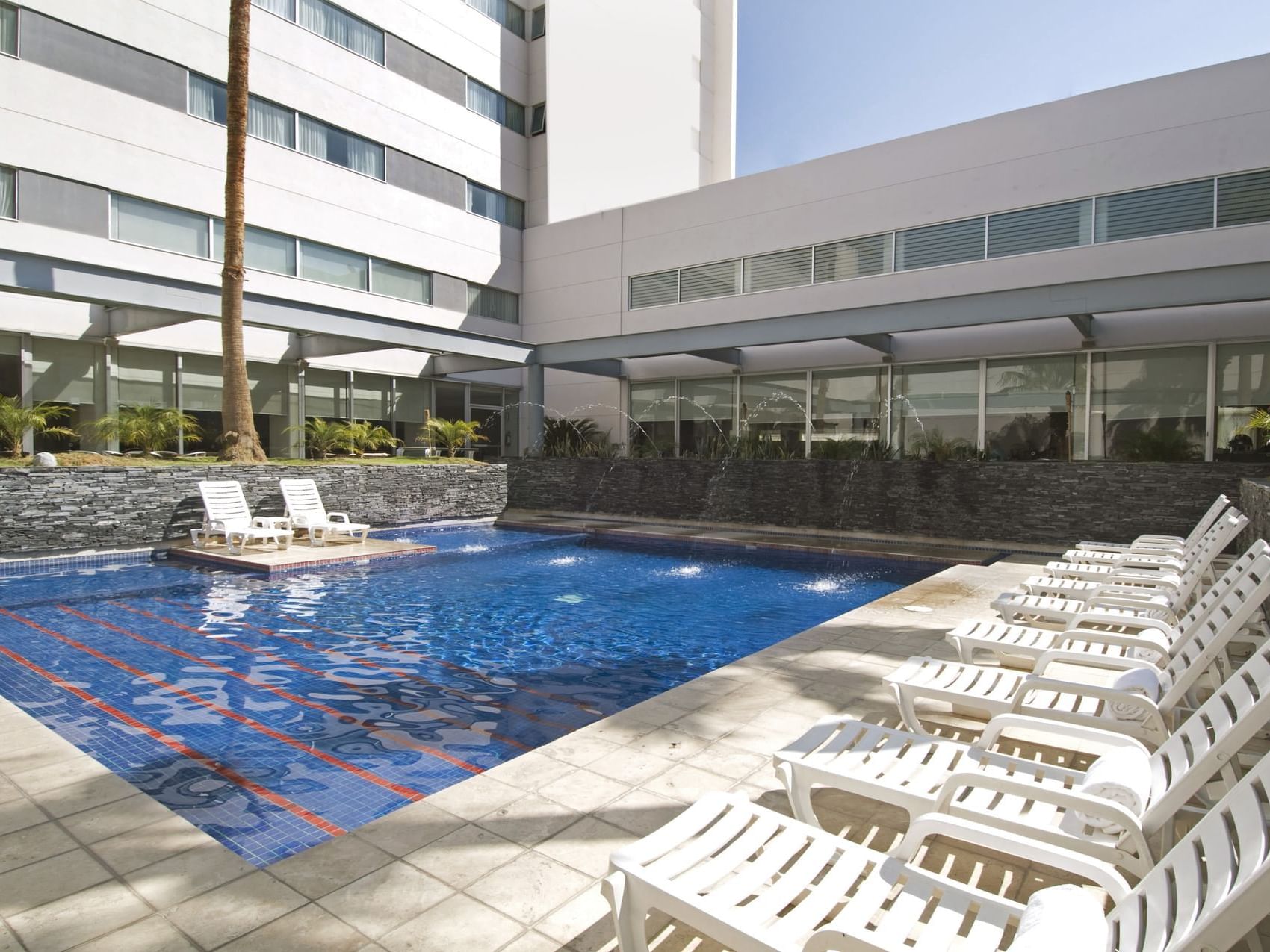 Outdoor Swimming pool with sunbeds at Fiesta Inn Hotels