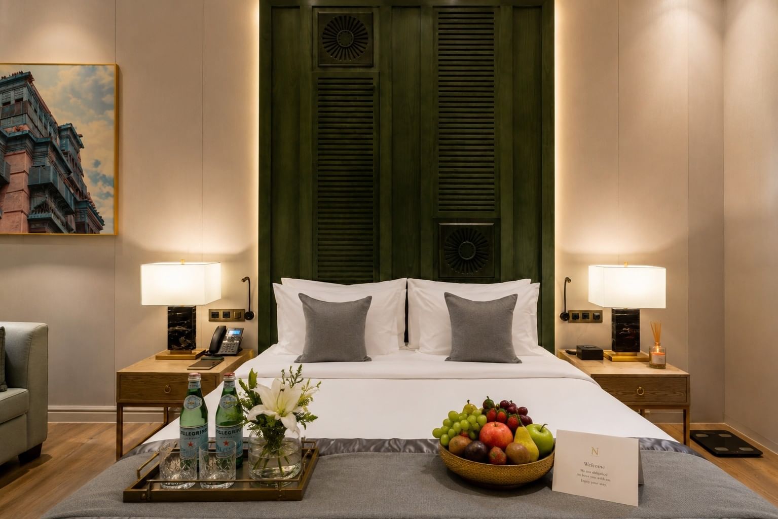Fruit bowl & flowers on bed tray between lamps in Deluxe Room at Naviti by Warwick Jeddah, featuring a peaceful boutique stay