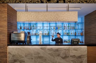 Lady preparing drinks by the Bar counter in Marigold Bar at Park Hotel Hong Kong
