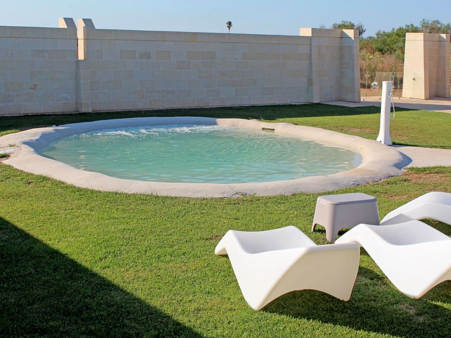 Exterior view of circular pool with pool beds at Masseria Stali