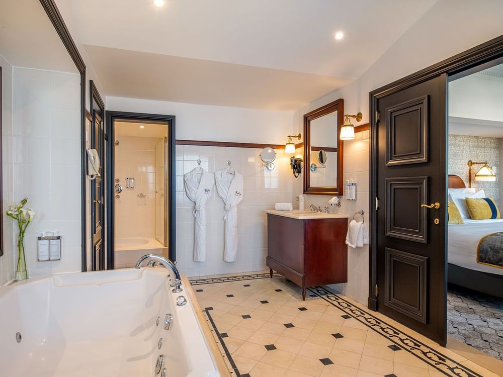 Ruime badkamer met bubbelbad en aparte douche in Hotel Barsey by Warwick.