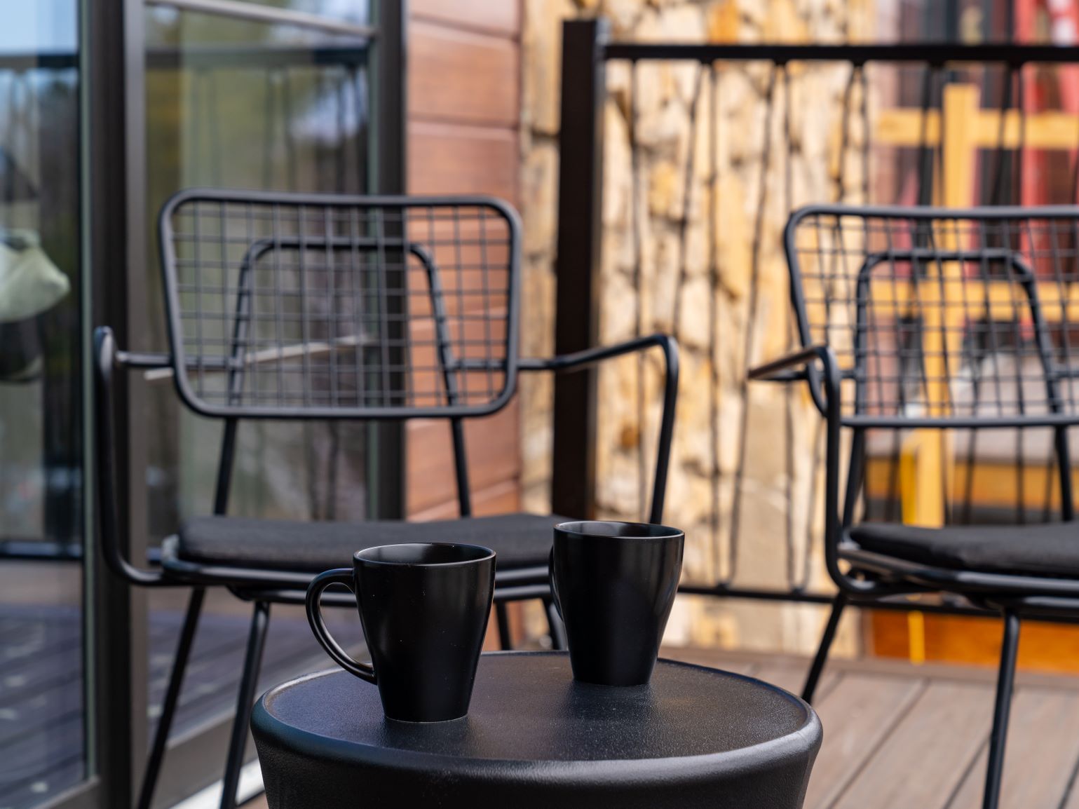 Arranged seating and coffee cups in King Junior Suite Room's balcony at The Earl