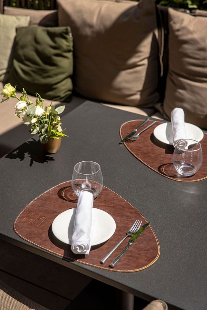 An outdoor dining table arranged with cutlery at EMME Restaurant