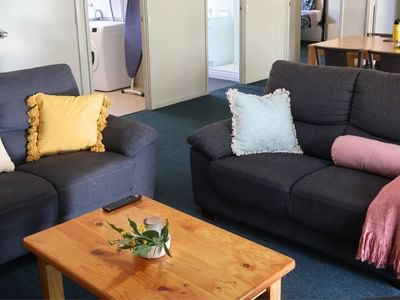 Two couches with a wooden table and flower pot in between at La Trobe University - Villas.