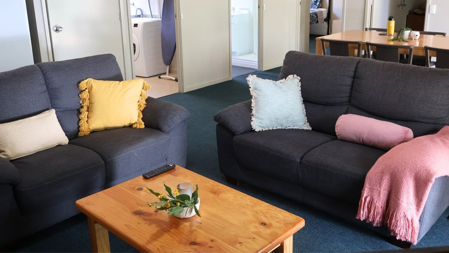 Two couches with a wooden table and flower pot in between at La Trobe University - Villas.