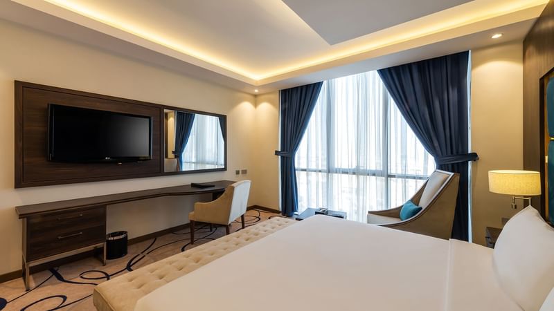 Cozy bed, TV and sitting area in Standard Room at Warwick Riyadh