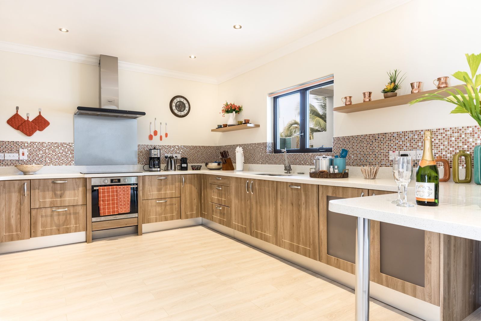 Modern kitchen with wooden cabinets, stylish decor, and appliances, featuring a window at Water's Edge Villas