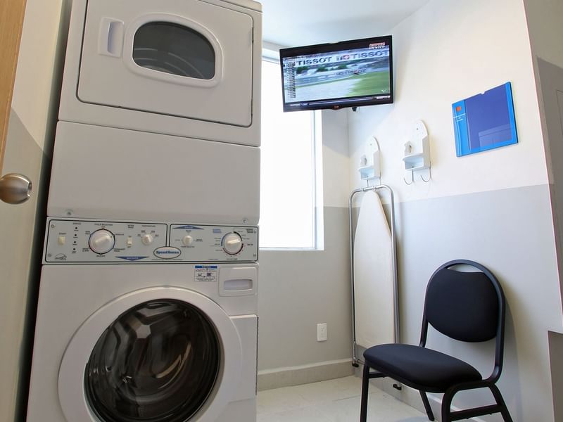 Washing machine, dryer & a chair in Laundry Room at One Hotels