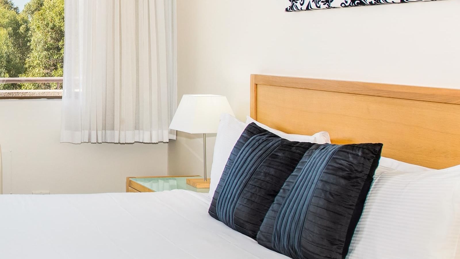 The bedroom arrangement in Privilege King room with a window overlooking the view at Mercure Charlestown