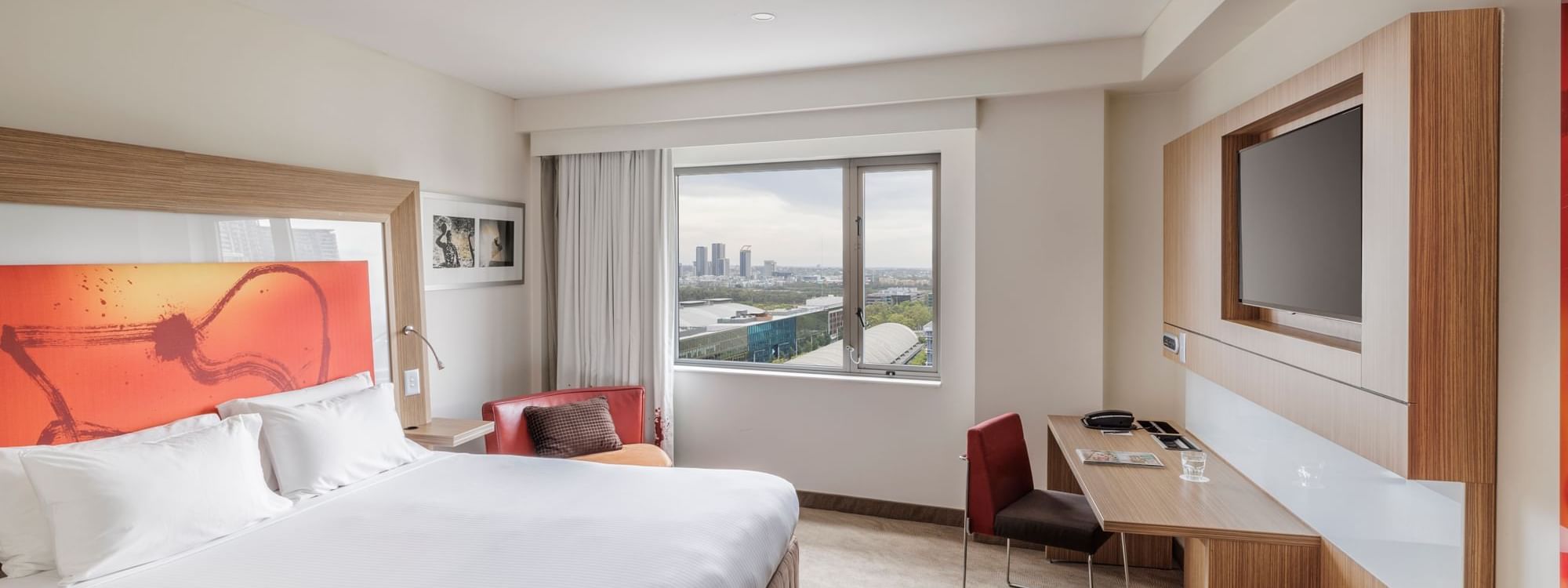 TV and work desk by the comfy bed in Superior Accessible Room with views of Accor Stadium at Novotel Sydney Olympic Park