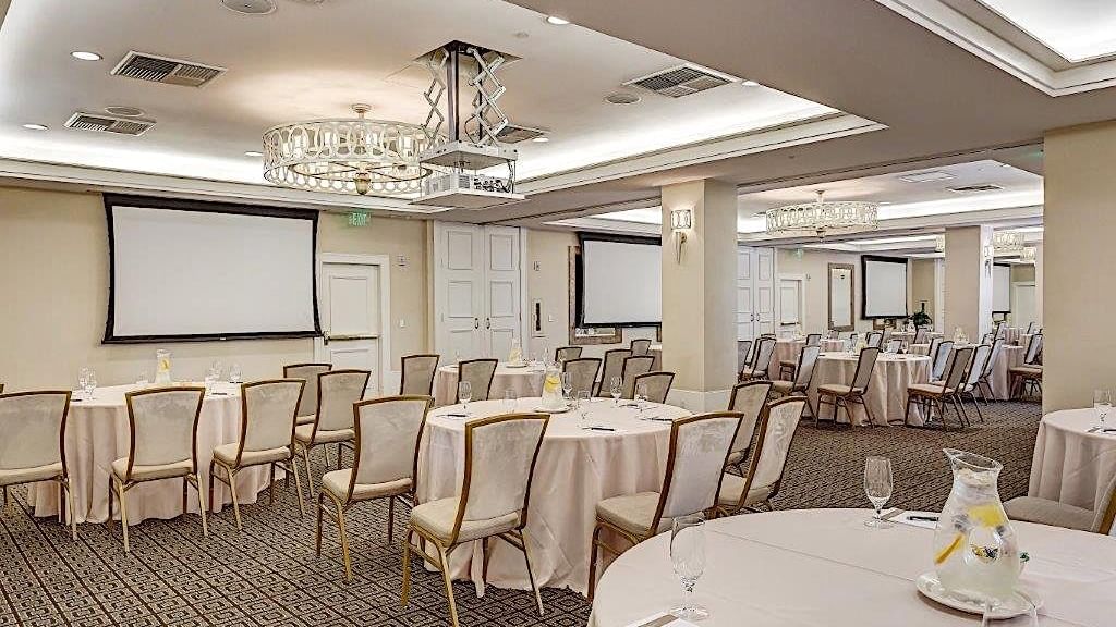 Courtyard Ballroom at El Prado Hotel, set with round tables, screens, and elegant chandeliers