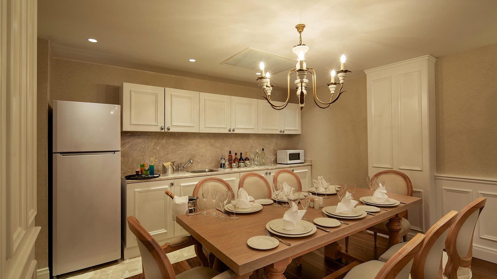 Вилла Superior в Titanic Deluxe Golf Belek — компактная кухня с обеденным столом для уютных трапез.