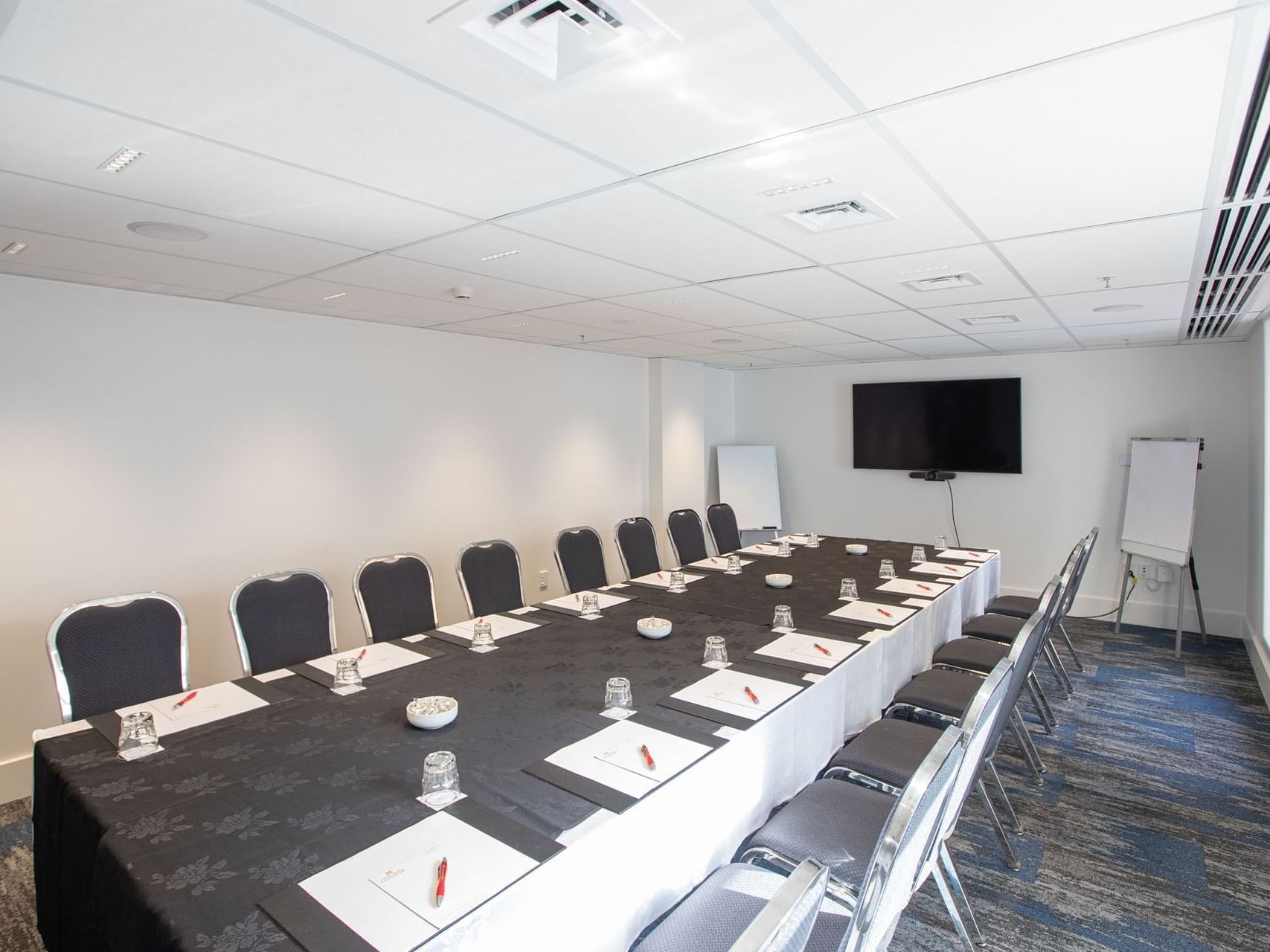 Conference table set-up in Boardroom 3 with carpeted floors at James Cook Grand Chancellor