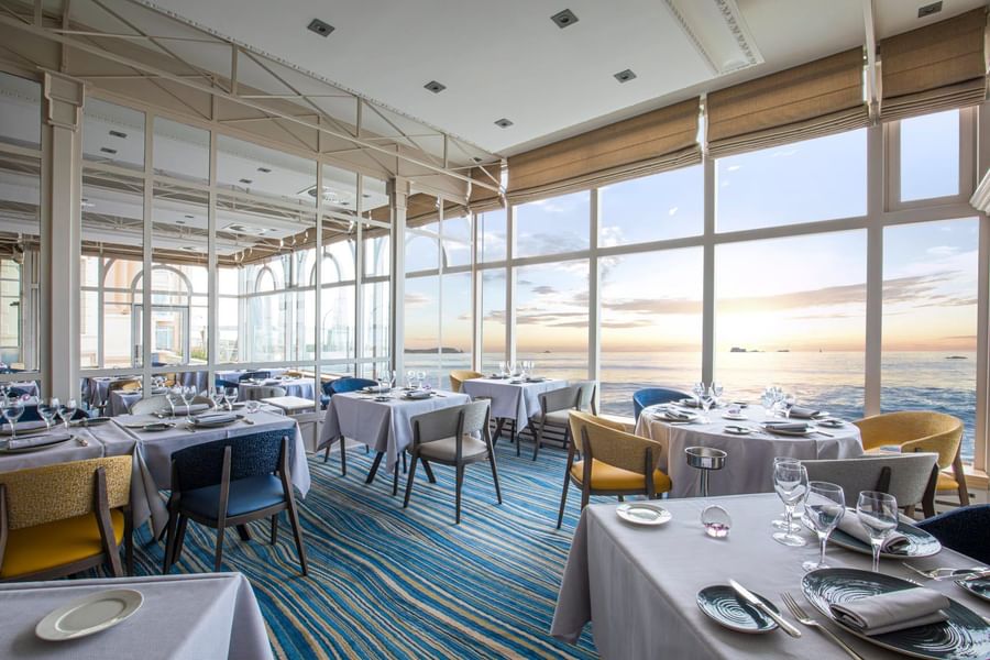 Dining tables arranged with a sea view in Le Cap Horn at Le Grand Hôtel des Thermes