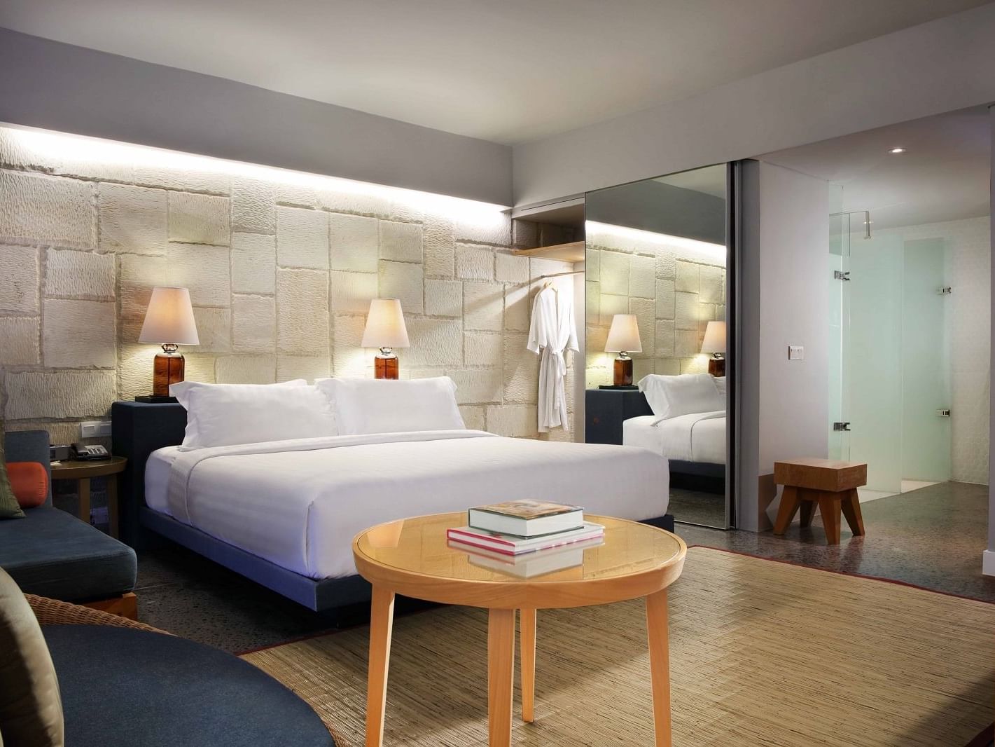 King size bed with book table in a suite at U Hotels & Resorts
