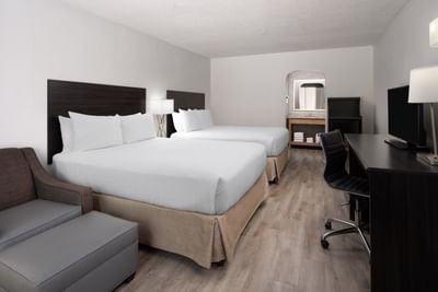 Deluxe Two Queens with two queen beds, dark headboards, and a office desk area at The Harrison Hotel Downtown Hollywood