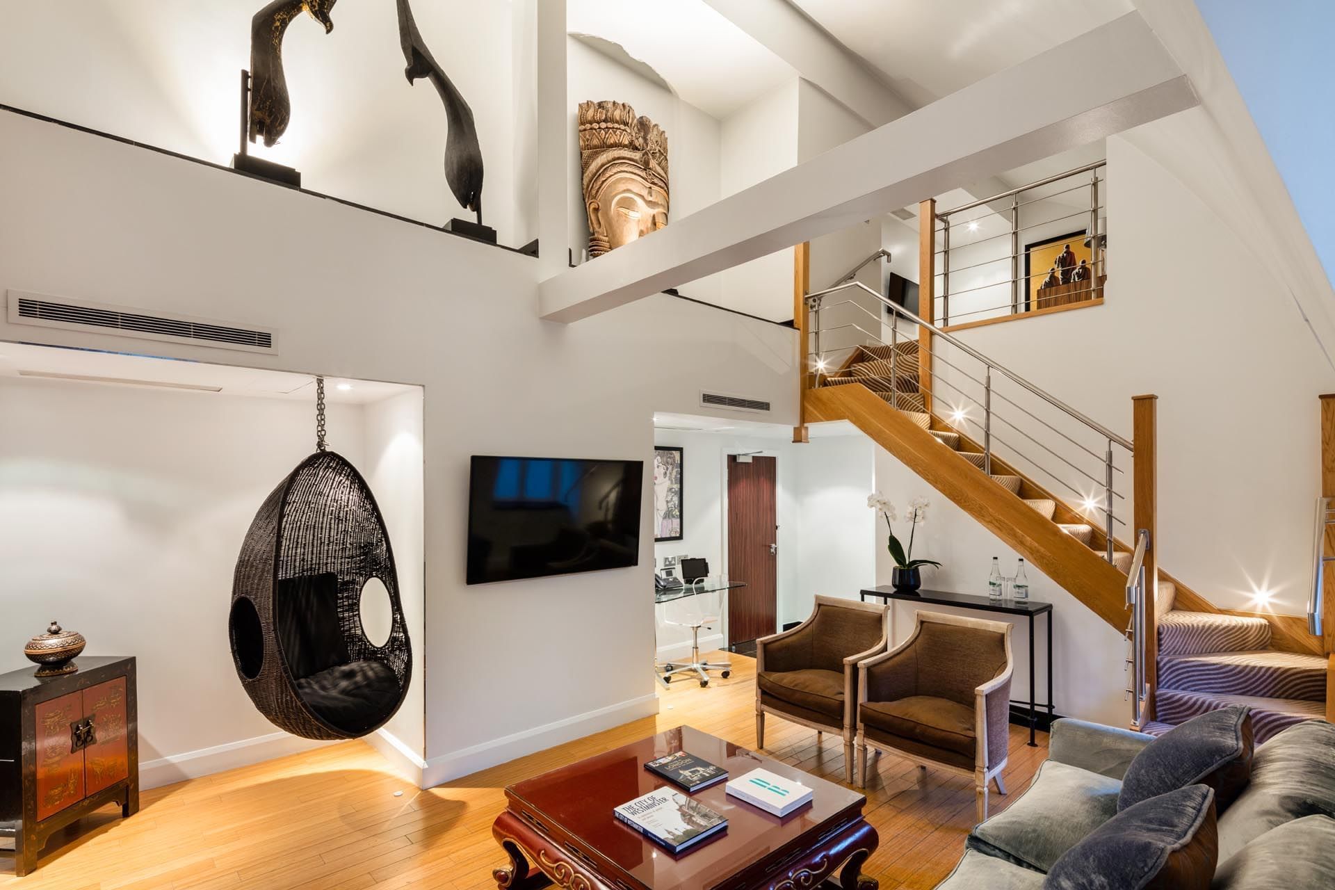 Interior of Duplex suite featuring a large sectional sofa and modern decor at The May Fair Hotel