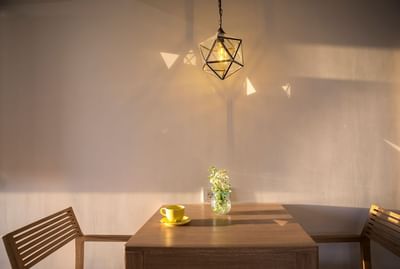 A table with two chairs and a lamp in Junior Suite at Eastin Ashta Resort Canggu