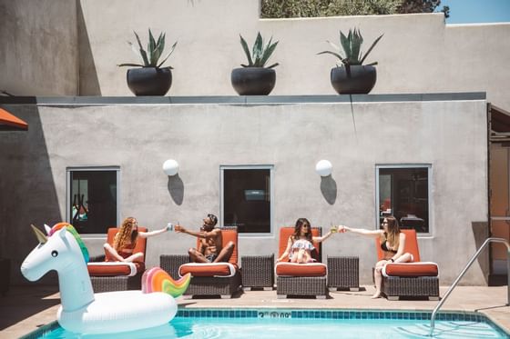 Guests having cocktails in a pool area at Hotel Angeleno