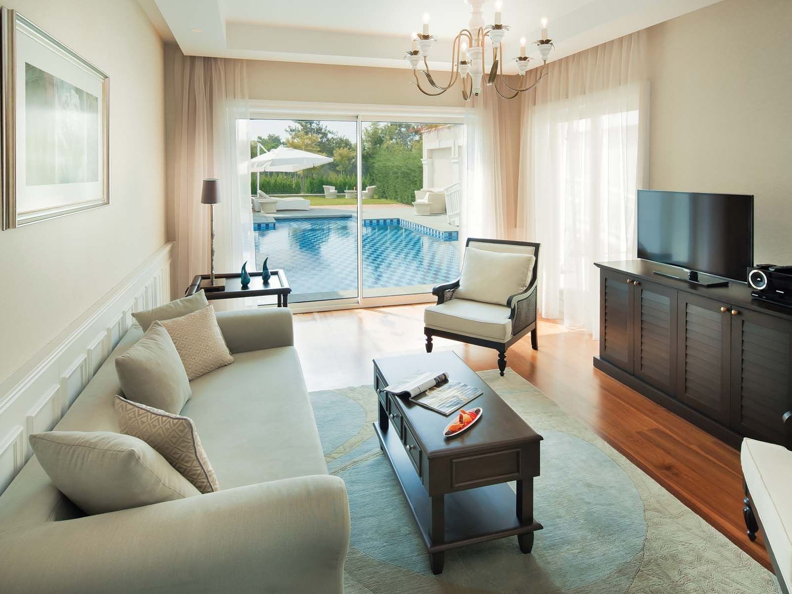 TV lounge area in Design Pool Villa with wooden floors at Titanic Deluxe Golf Belek