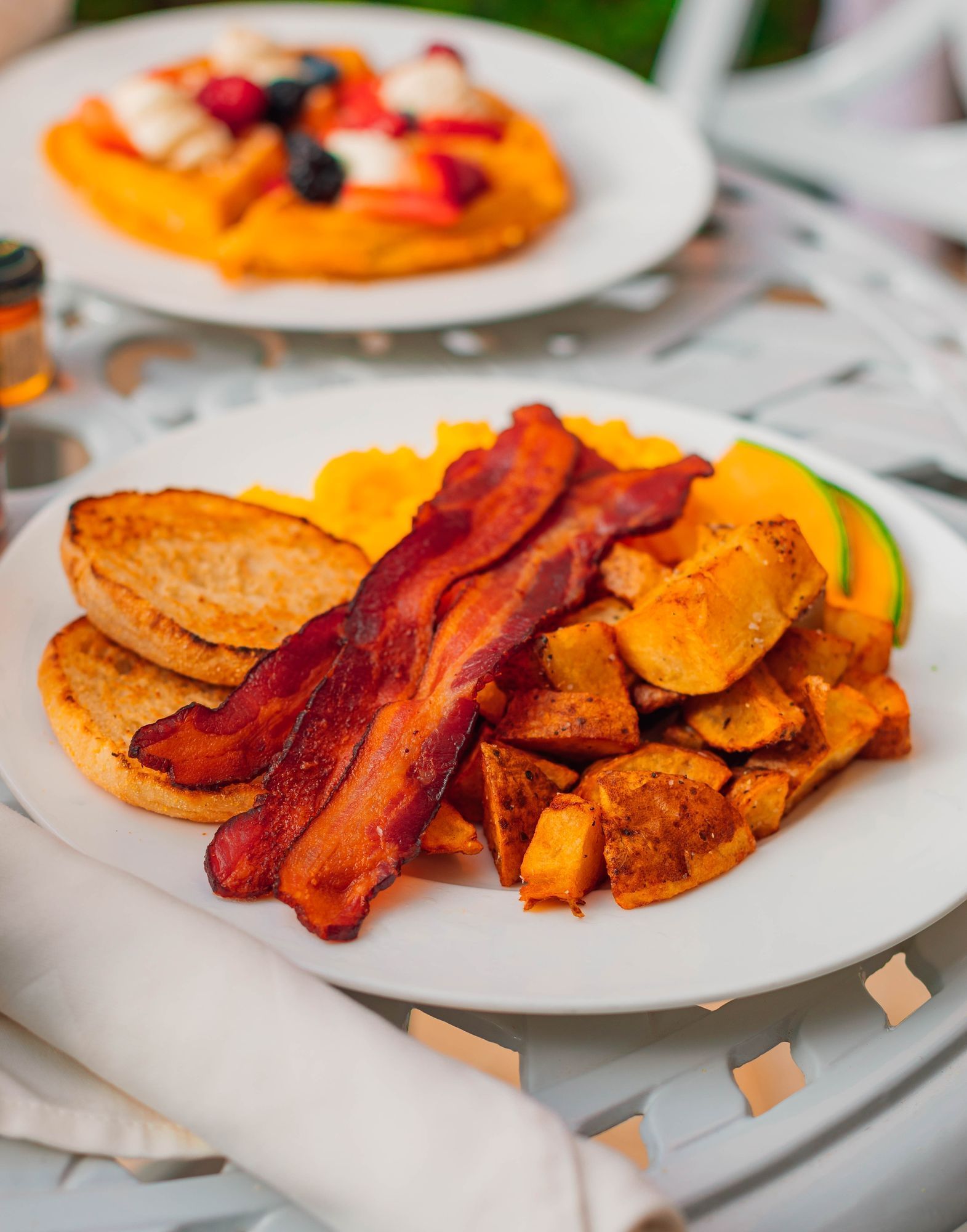 Lorem ipsum Plated breakfast plate with bacon, potatoes and English muffin