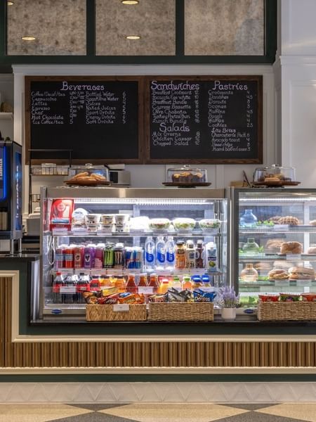 Beverage and pastry display cases with snacks in baskets at Allerton Cafe and Lounge in Warwick Allerton Chicago 