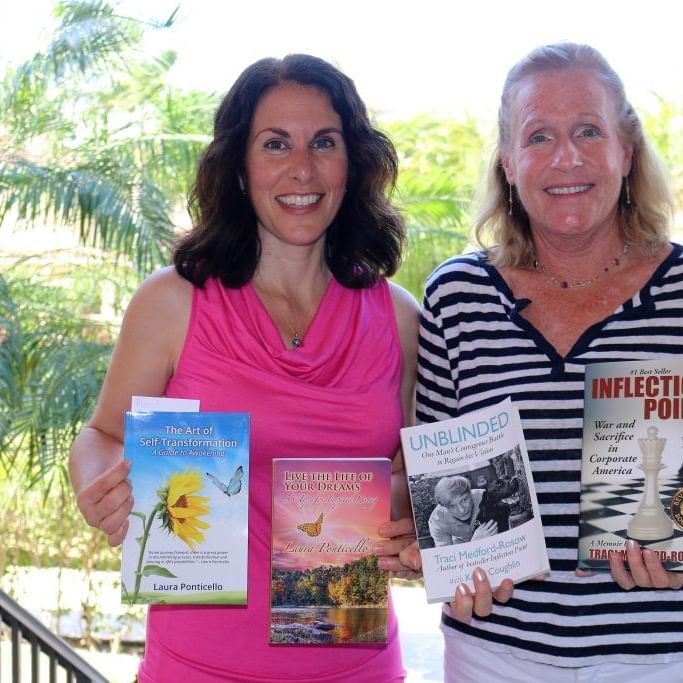 Two ladies holding books on there hands at Somerset Grace Bay