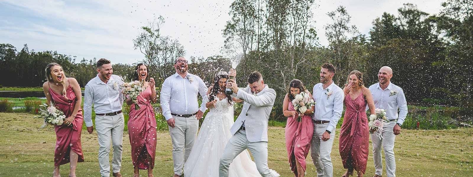 wedding group popping champagne on golf course