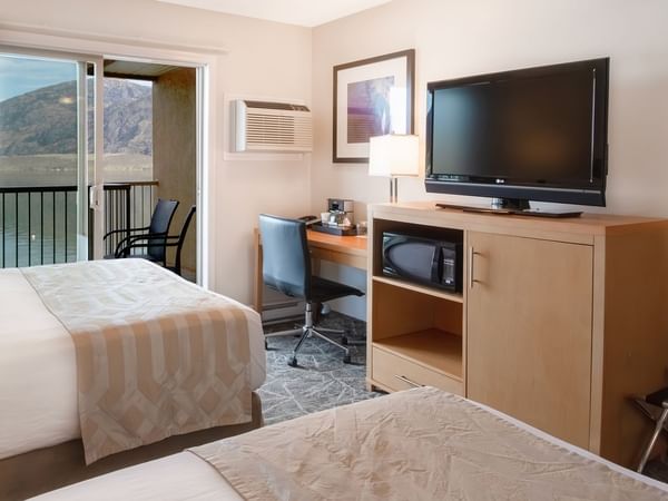 Two beds in hotel room with lake view