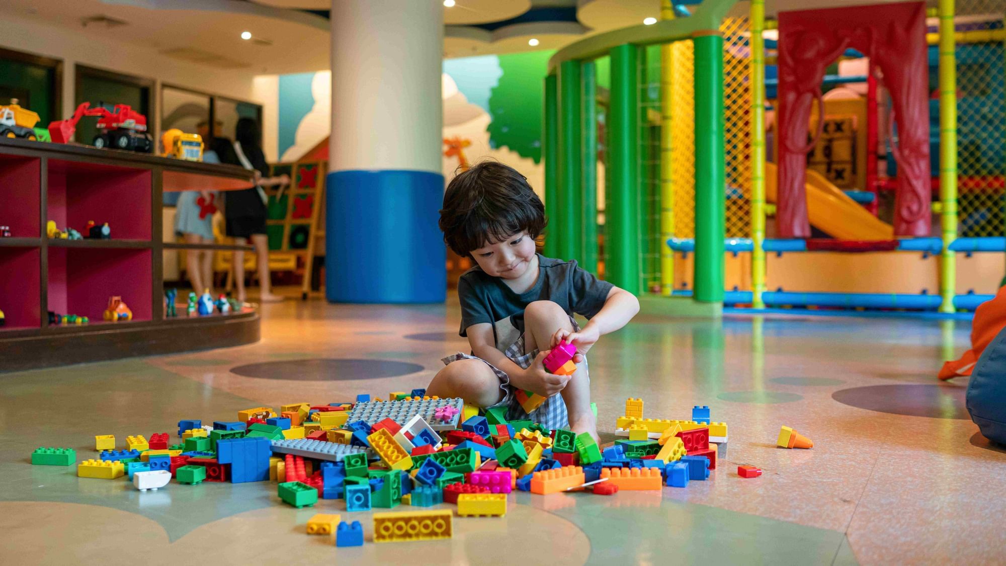 A kid is playing the Lego in the kids club